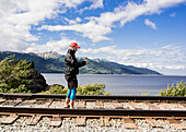 USA, Alaska, Man photographing railroad tracks in Kenai Fjords National Park