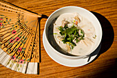 Laos, Luang Prabang, Overhead view of soup and fan on table