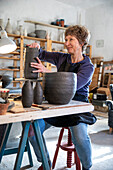 Spanien, Balearen, Frau macht Keramik in Werkstatt