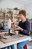 Spain, Baleares, Woman painting ceramics in workshop