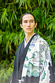 UK, Porträt eines jungen Mannes im Kimono im Park