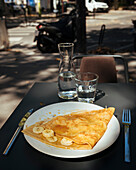 Frankreich, Paris, Crepes mit Bananenscheiben auf einem Teller im Freien
