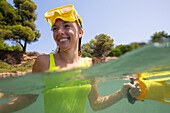 Spanien, Mallorca, Lächelnde Frau mit Tauchermaske im Meer