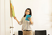 Germany, Freiburg, Woman looking at tablet in office