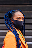 Italy, Milan, Portrait of fashionable woman with face mask and braided hair