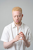 Studio-Porträt von Albino-Mann in weißem Hemd mit geschlossenen Augen
