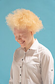 Studio-Porträt einer lächelnden Albino-Frau in weißem Hemd