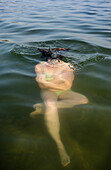 Netherlands, Noord-Brabant, Breda, Woman submerging in lake