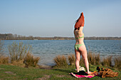 Netherlands, Noord-Brabant, Breda, Woman undressing on lakeshore