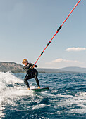 Junge (12-13) beim Wakeboarden auf dem See
