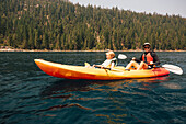 Vater mit Sohn (7-8) im Kajak auf dem See