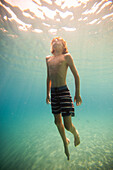 Junge (12-13) schwimmt unter Wasser