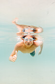 Junge (12-13) schwimmt unter Wasser