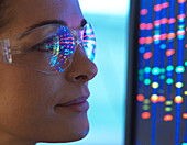 Close-up of scientist with DNA sequencing reflected in eyeglasses