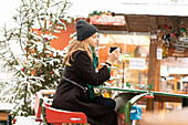 Junge Frau mit Getränk auf dem Weihnachtsmarkt