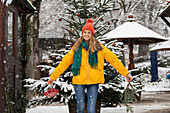 Portrait of smiling young woman standing outdoors in winter