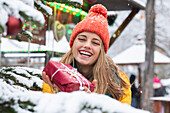 Smiling young woman holding Christmas present outdoors