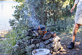 Man cooking meal on campfire