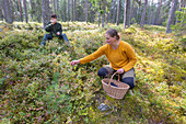 Frau und Junge (16-17) beim Beerensammeln im Wald