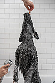 Junge (12-13) wäscht Hund in der Badewanne