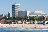 Strand am Wasser mit Häusern, Gebäuden und Palmen im Hintergrund; Kalifornien, Vereinigte Staaten von Amerika