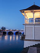 Gebäude und eine Brücke entlang des Flusses in der Abenddämmerung; Kingston Upon Thames, England
