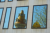 Reflection Of A Unique Tower, Tree And Blue Sky In A Building Window; Barcelona, Spain