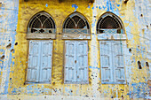 Zerbrochene Fenster und alte Fensterläden an einem verwitterten und abgenutzten Gebäude; Beirut, Libanon