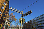 Straßenschilder an einer Kreuzung mit Gebäuden und blauem Himmel; Hamburg, Deutschland