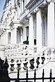 Ein verziertes weißes Gebäude mit Geländern und Säulen, Kensington; London, England