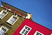 Ein Backsteingebäude mit einem Schild mit der Aufschrift Take Courage", Camden; London, England"