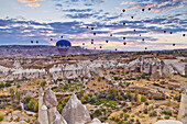 Eine Vielzahl von Heißluftballons über der zerklüfteten Landschaft des Honigtals; Kappadokien, Türkei
