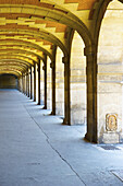 Ein überdachter Gehweg mit Säulen und gewölbter Decke, Marais-Viertel; Paris, Frankreich.