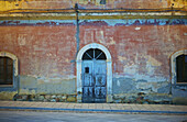 Ein altes Gebäude mit bogenförmiger Tür und Fenster; Sardinien, Italien