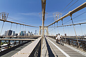 Couple On A Tandem Bicycle On The Pedestrian Walkway On The Brooklyn Bridge, New York City, New York, United States