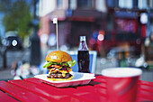 A Large Hamburger And Bottle Of Pop On A Table; London, England