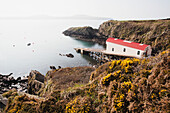 St. Justinian's Lifeboat Station mit Ramsey Island in der Ferne auf dem Pembrokeshire Coast Path; Pembrokeshire, Wales