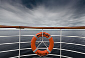 Ein Rettungsring, der an der Reling eines Bootes hängt; Norwegen
