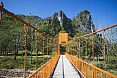 Eine Brücke führt zu Höhlen außerhalb von Vang Vieng; Laos