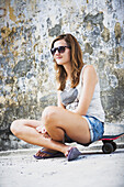 Young Female Tourist With A Skateboard On A Downtown Street; Penang, Malaysia