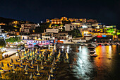 Colourful Lights Illuminate And Reflect On The Water In The Harbour; Bali, Crete, Greece
