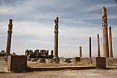 Säulen der Apadana-Halle, im Hintergrund der Winterpalast des Dareios; Persepolis, Iran.