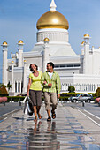 Couple Shopping With Sultan Omar Ali Saifuddien Mosque In The Background; Bandar Seri Begawan, Brunei