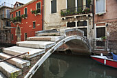 Eine malerische Brücke überquert einen kleinen Kanal; Venedig, Italien