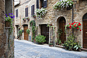A Quaint Village With Flowers Decorating Residential Buildings; Pienza, Tuscany, Italy