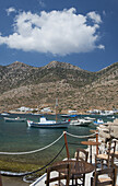 Taverne Tische und Stühle auf einem Steinpier im Hafen von Kamares; Kamares, Sifnos, Kykladen, Griechische Inseln, Griechenland