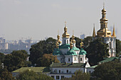 Die Kuppeln der entfernten Höhlen in der Pecherska Lawra und in der Ferne im Bau befindliche Hochhäuser; Kiew, Ukraine