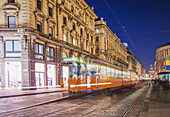 Bewegungsunschärfe der Straßenbahn, die die Straße hinunterfährt; Mailand, Lombardei, Italien
