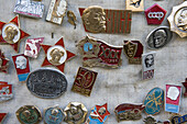 Emailleabzeichen mit Lenin und anderen Motiven der kommunistischen Herrschaft Russlands zum Verkauf an einem Souvenirmarktstand am St. Andrew's Descent; Kiew, Ukraine