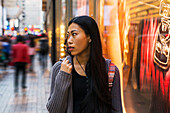 Eine junge Frau beim Einkaufen auf der Straße, Kowloon; Hongkong, China.